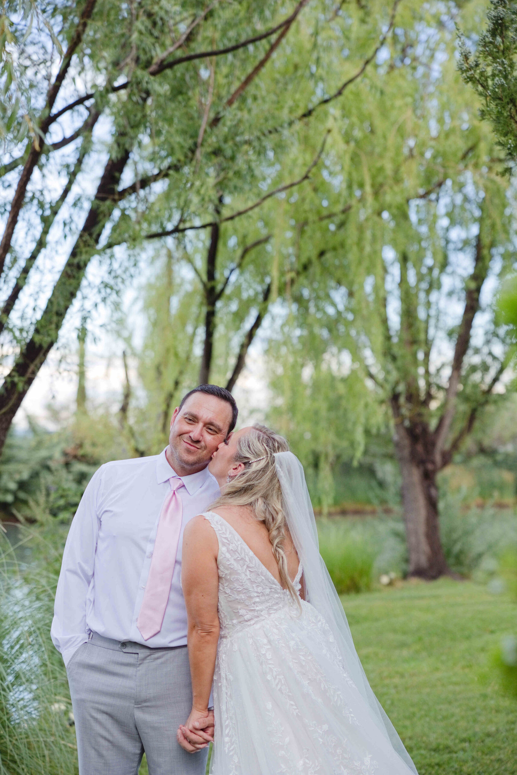 Bride and groom hugging against the windmill at the Windmill House during their portrait session