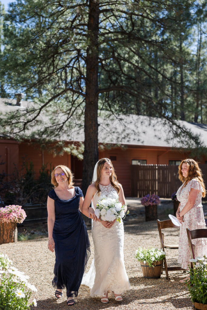 Mother of bride and bride walking down aisle at the ceremony site at Serendipity venue in Flagstaff.