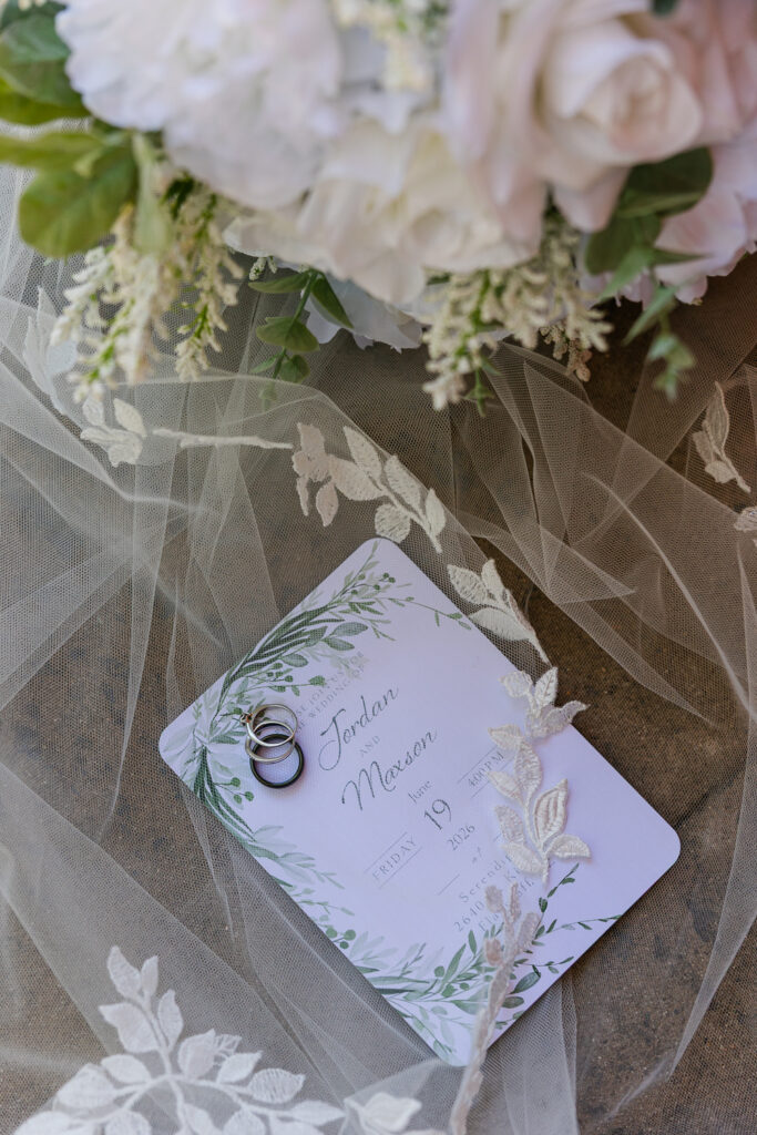 detail photo of wedding invitation and rings