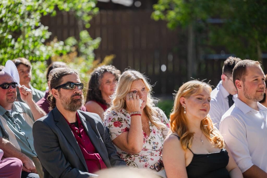 Wedding attendee crying during vows at the ceremony. 
