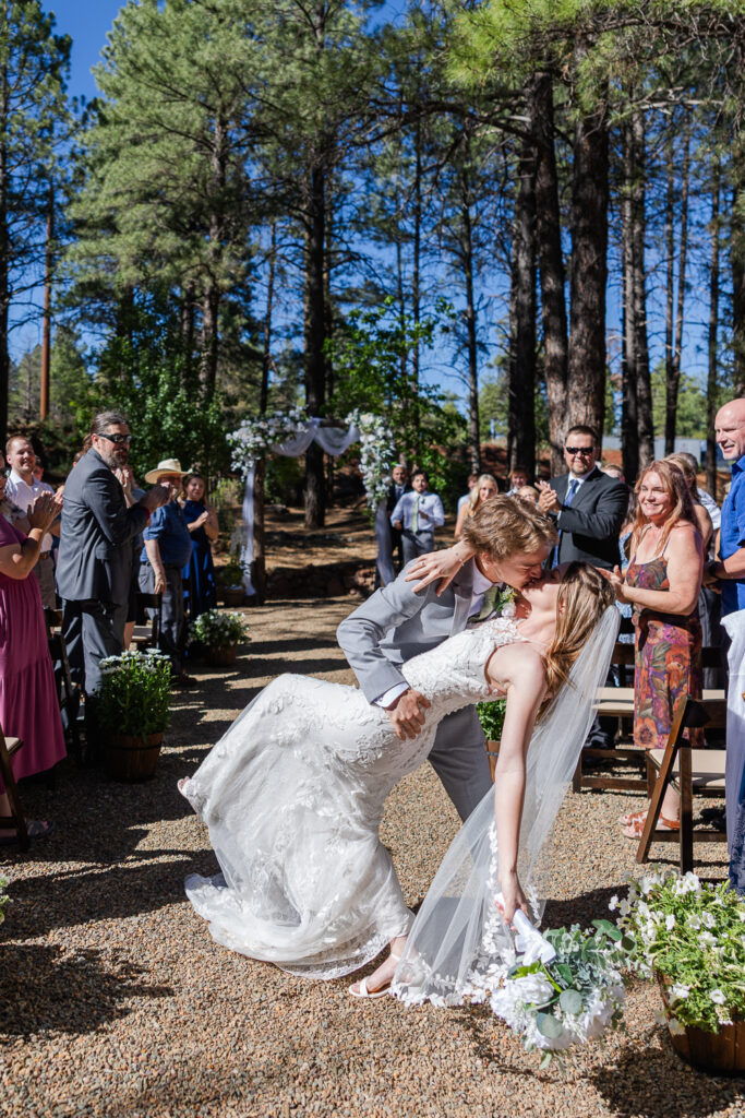 Bride and Groom kiss at the end of the aisle for an epic photo op. 